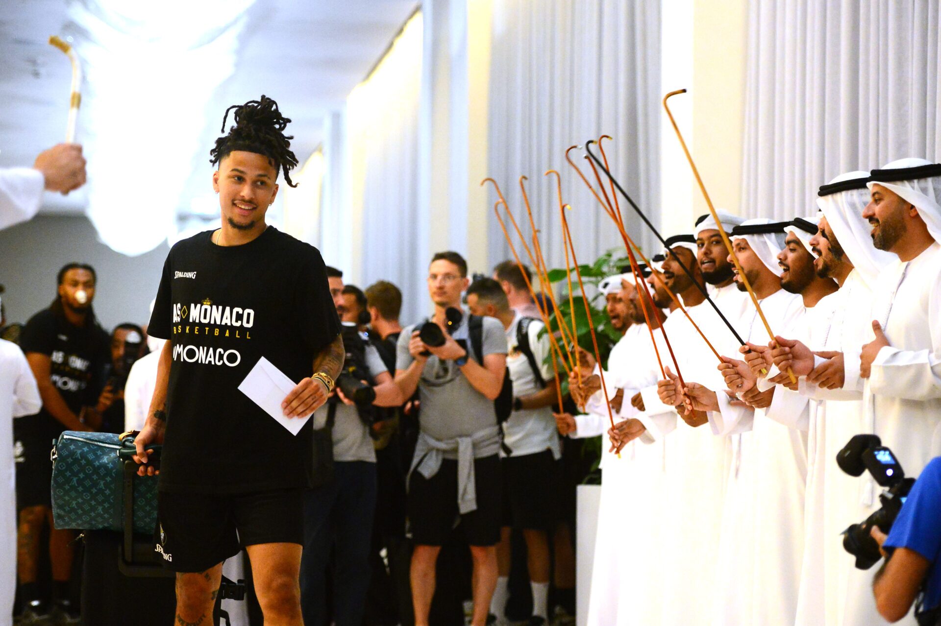 French basketballer Matthew Strazel, point guard for AS Monaco, is greeted by traditional Emirati dancers on arrival at the Hilton on Abu Dhabi’s Yas Island, where the Turkish Airlines EuroLeague Final Four will take place this weekend. (Luca Sgamellotti/Euroleague Basketball via Getty Images)