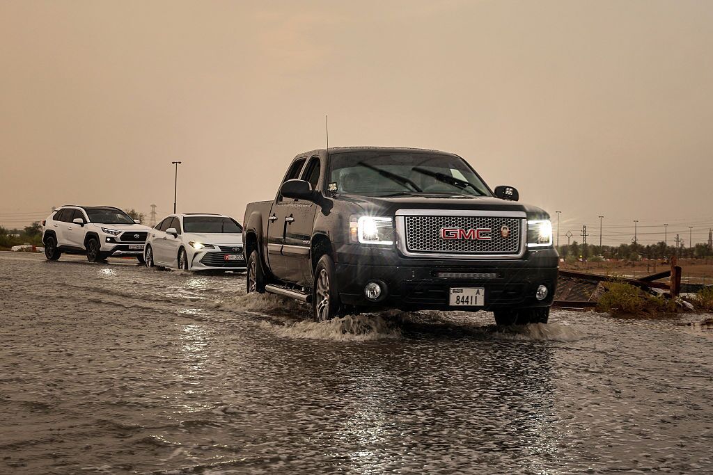 People drive their cars along a flooded road amid unseasonably heavy rainfall on the outskirts of Dubai on Monday. (Fadel Senna/AFP via Getty Images)